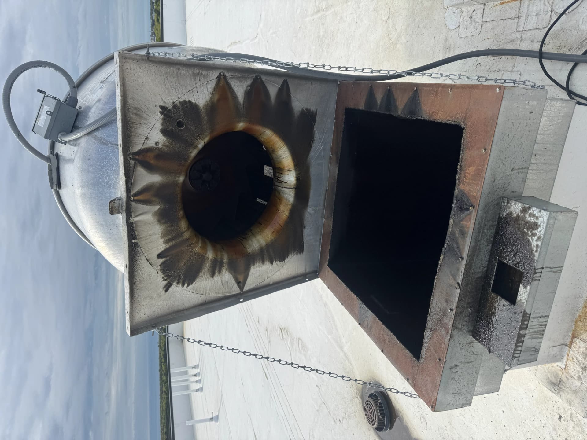 Grease-caked roof exhaust fan before cleaning — fire hazard